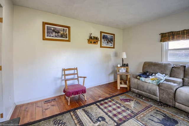 living area featuring hardwood / wood-style flooring, baseboards, and visible vents