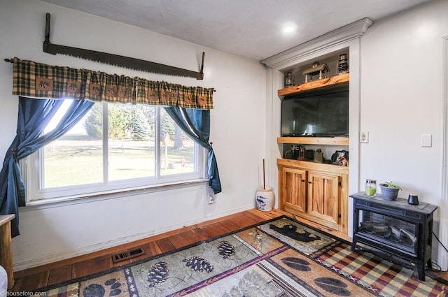 living room with visible vents, baseboards, and wood finished floors