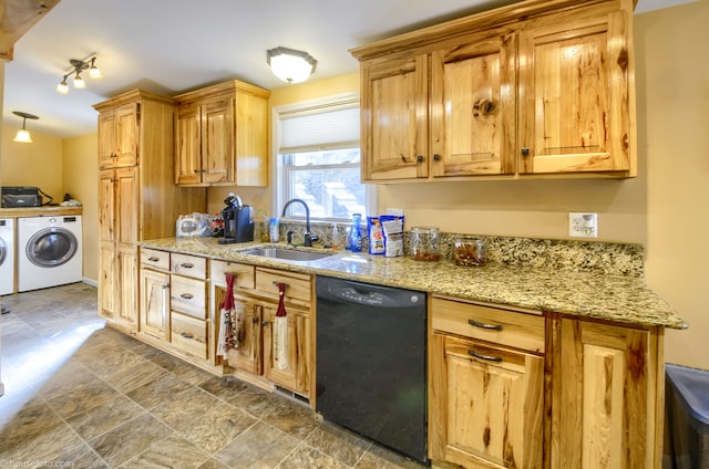 kitchen featuring light stone counters, a sink, stone finish flooring, dishwasher, and washing machine and dryer