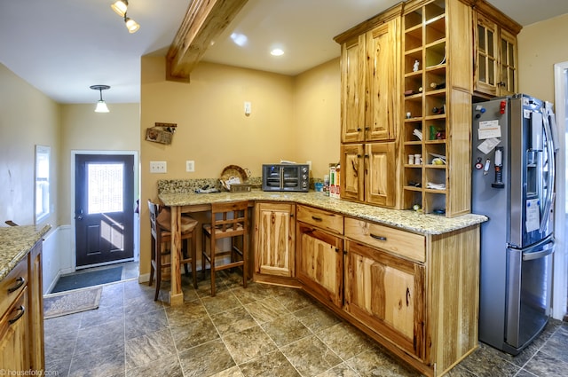 kitchen featuring beam ceiling, light stone counters, stone finish flooring, stainless steel fridge with ice dispenser, and glass insert cabinets