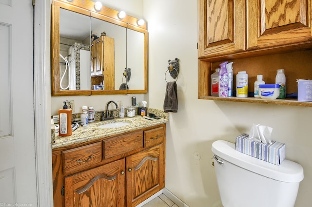 bathroom with toilet, vanity, and tile patterned flooring