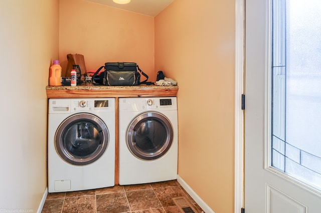 clothes washing area featuring visible vents, baseboards, separate washer and dryer, and laundry area