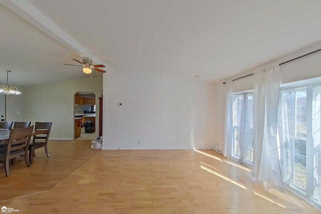 living room featuring vaulted ceiling with beams, baseboards, ceiling fan with notable chandelier, light wood-style floors, and arched walkways