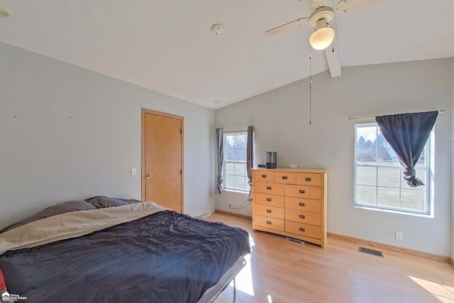 bedroom with a ceiling fan, baseboards, visible vents, light wood finished floors, and lofted ceiling with beams