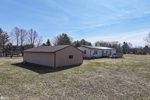 view of home's exterior with an outbuilding, a lawn, and a wooden deck