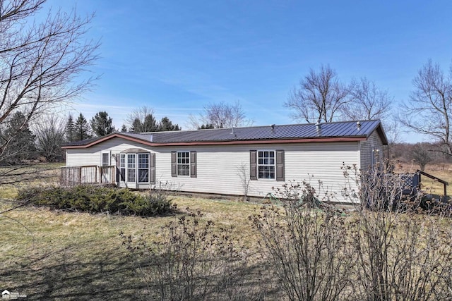 back of house featuring a deck and metal roof