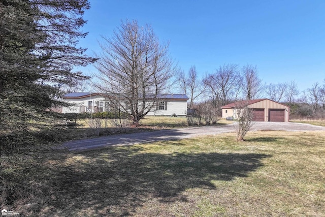 view of front of property with an outbuilding, driveway, and a front yard