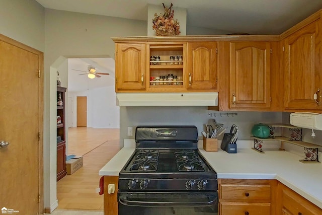 kitchen with ceiling fan, light countertops, black range with gas cooktop, under cabinet range hood, and brown cabinets