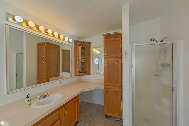 full bathroom featuring tile patterned floors, a stall shower, and vanity