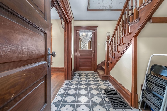 entrance foyer featuring tile patterned floors, stairs, and baseboards