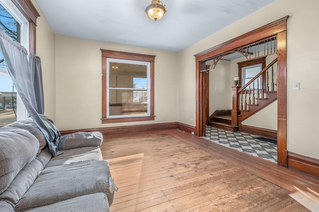 living room with baseboards, hardwood / wood-style floors, and stairs