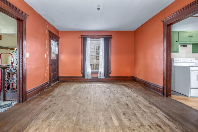 spare room featuring baseboards and wood-type flooring