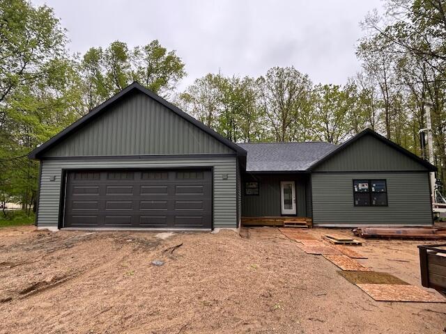 6897 Abbey Ln, Canadian Lakes, MI 49346 - view of front of house with driveway and an attached garage