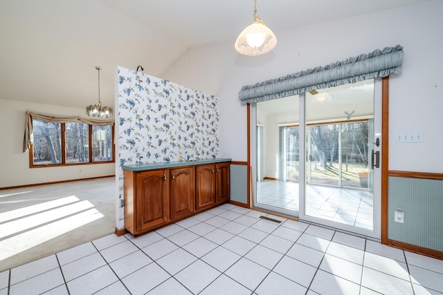 unfurnished room featuring light tile patterned floors, visible vents, a notable chandelier, and vaulted ceiling