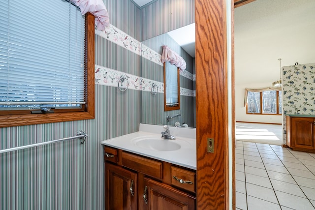 bathroom featuring vanity, tile patterned flooring, and wallpapered walls