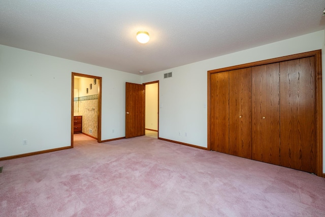 unfurnished bedroom featuring a closet, visible vents, carpet floors, and a textured ceiling