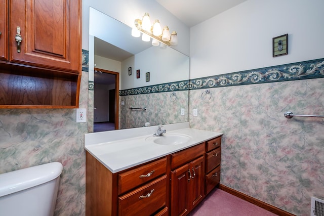 bathroom featuring visible vents, toilet, tile walls, wainscoting, and vanity