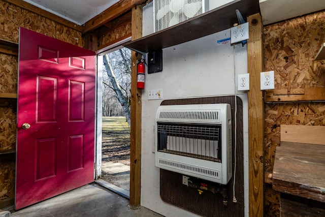 foyer featuring heating unit and unfinished concrete flooring