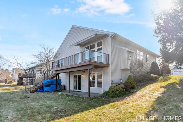 back of house featuring a yard, a wooden deck, stairs, and a patio area