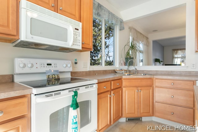 kitchen with visible vents, white appliances, light countertops, and a sink