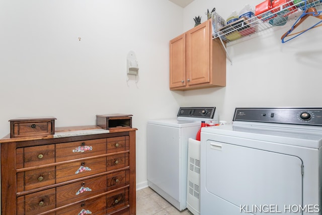 clothes washing area with light tile patterned floors, cabinet space, and separate washer and dryer