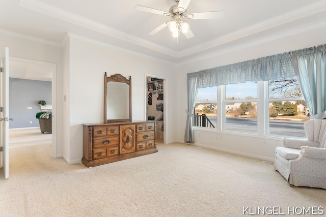 sitting room with baseboards, light colored carpet, a tray ceiling, ornamental molding, and a ceiling fan