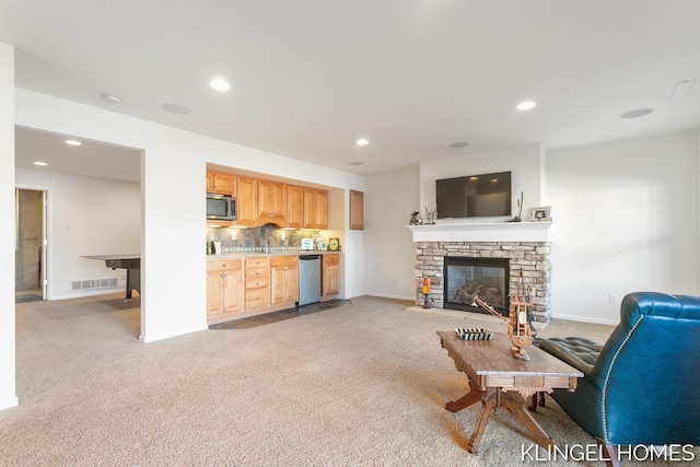 living room featuring visible vents, baseboards, light colored carpet, recessed lighting, and a fireplace