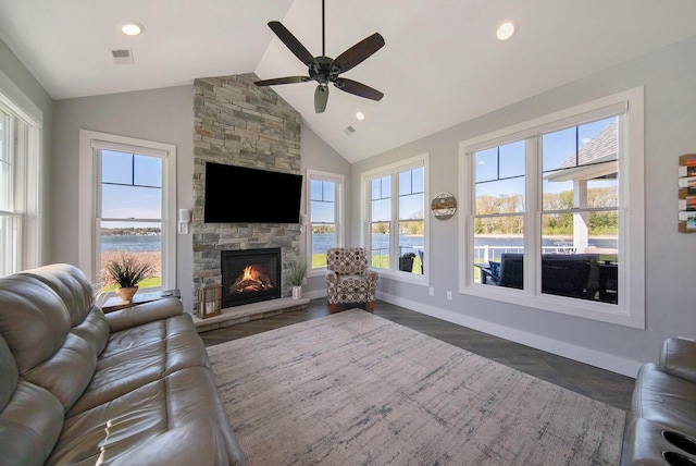 living area featuring dark wood finished floors, visible vents, plenty of natural light, and a fireplace