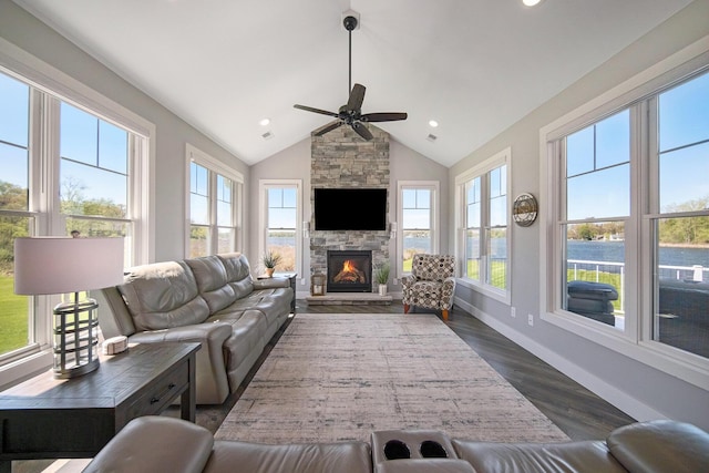 living area with baseboards, a healthy amount of sunlight, dark wood finished floors, and vaulted ceiling