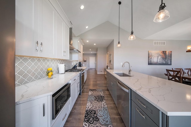 kitchen with visible vents, a sink, stainless steel appliances, dark wood-style flooring, and vaulted ceiling