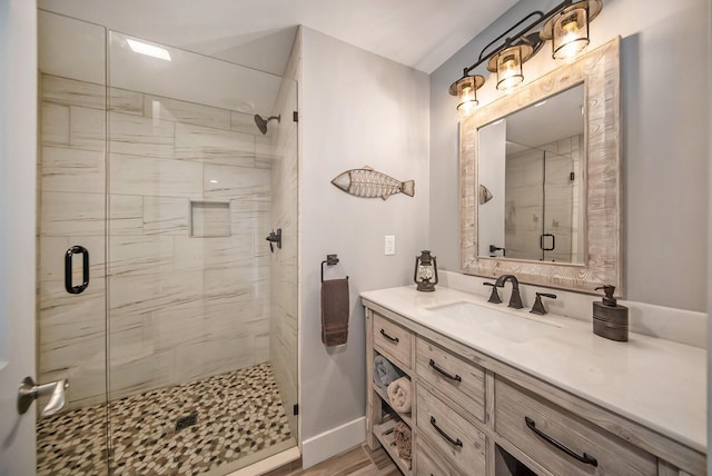 bathroom featuring baseboards, vanity, and a shower stall