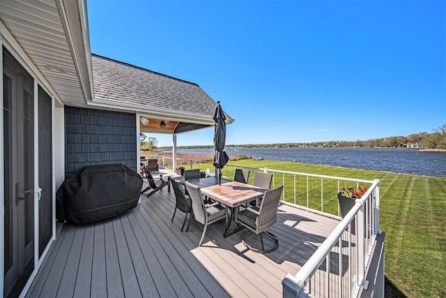 wooden terrace with area for grilling, outdoor dining space, a lawn, and a water view