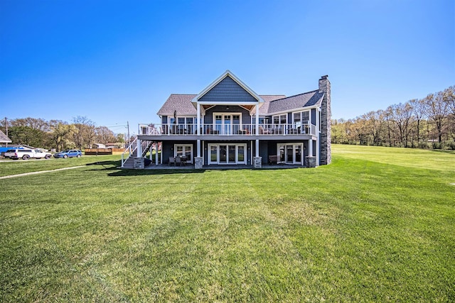 rear view of property with stairway, a lawn, a chimney, and a deck