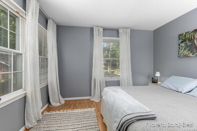 bedroom featuring baseboards and wood finished floors