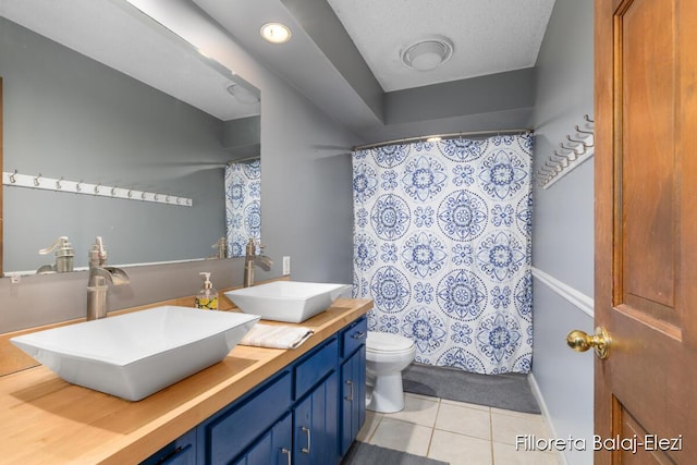 full bathroom featuring tile patterned flooring, double vanity, toilet, and a sink