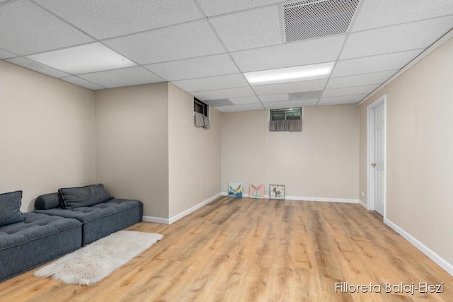 finished basement with visible vents, a paneled ceiling, baseboards, and wood finished floors