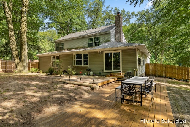 rear view of property with a wooden deck, fence, and entry steps