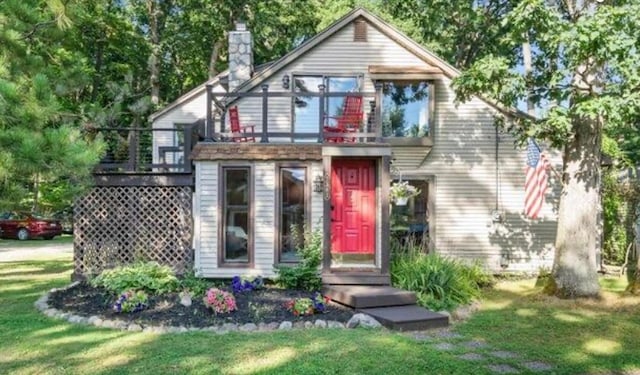 exterior space with a chimney, a deck, and a front yard