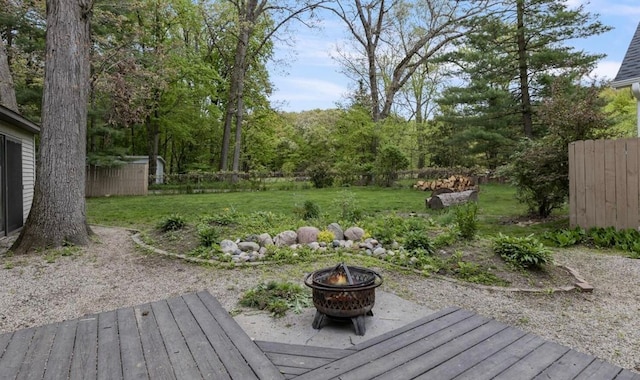 deck featuring a yard, a fire pit, and fence