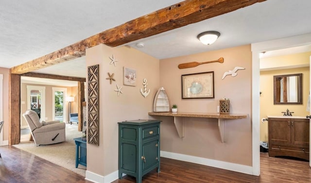 interior space featuring beamed ceiling, baseboards, and dark wood finished floors