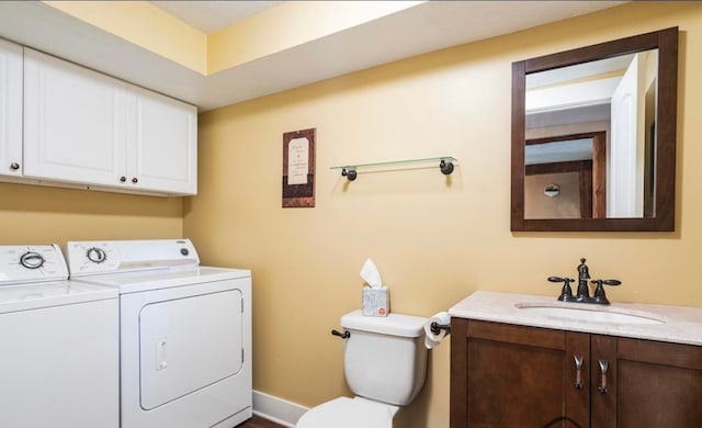 half bath with washing machine and dryer, vanity, and toilet