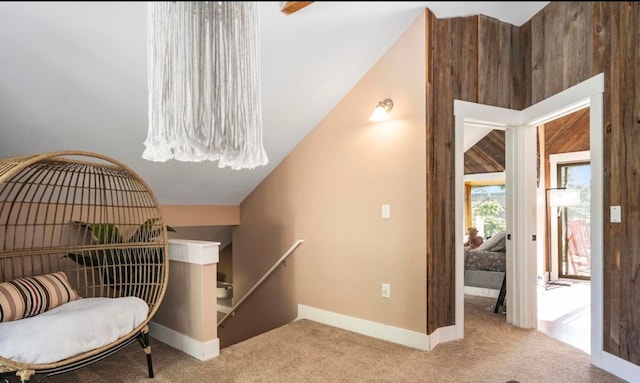 living area with an upstairs landing, carpet flooring, baseboards, and vaulted ceiling