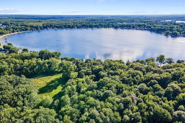 drone / aerial view featuring a wooded view and a water view