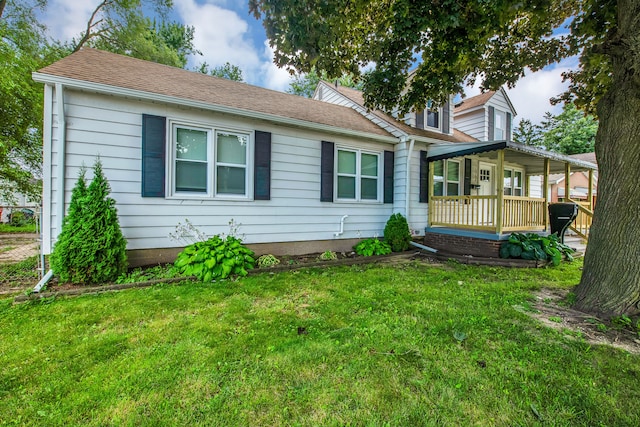 view of front of home featuring a front lawn, a porch, and roof with shingles