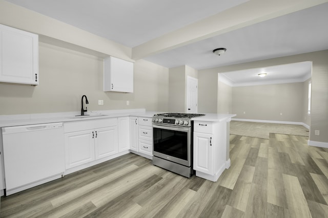 kitchen featuring a sink, gas stove, a peninsula, white dishwasher, and light countertops