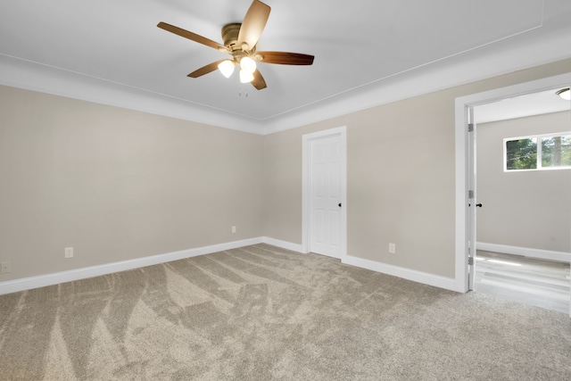 empty room with carpet flooring, ceiling fan, and baseboards