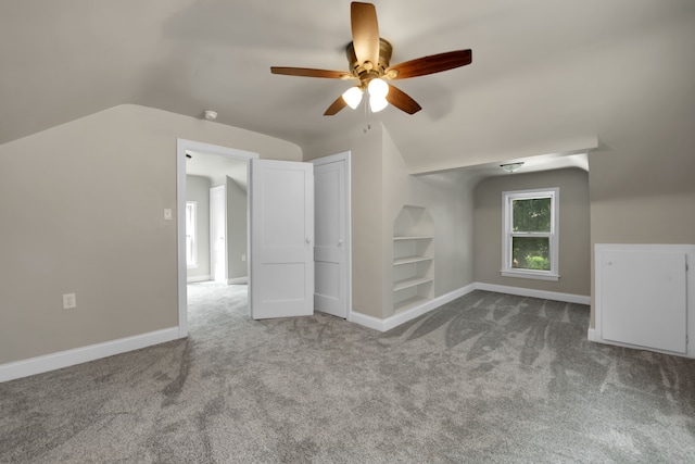 additional living space featuring lofted ceiling, built in features, baseboards, and carpet floors