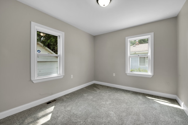 empty room with visible vents, baseboards, and carpet flooring