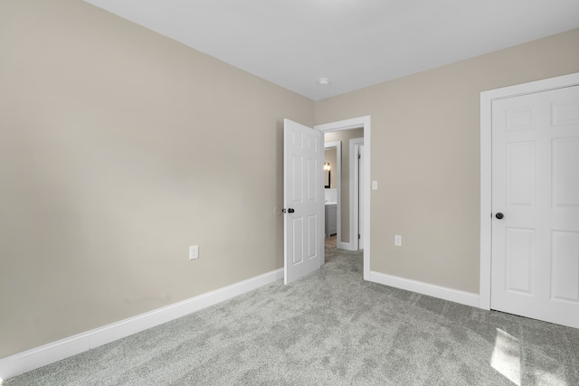 unfurnished bedroom with baseboards and carpet