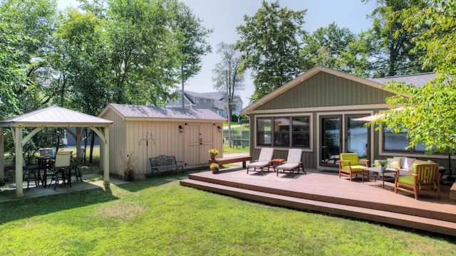 back of property featuring a shed, a gazebo, an outdoor hangout area, an outdoor structure, and a deck